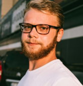 man in white crew neck shirt wearing black framed eyeglasses