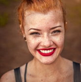 woman taking photo while showing smile