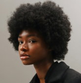 a woman with an afro is looking at the camera