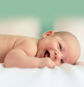 baby lying on fabric cloth